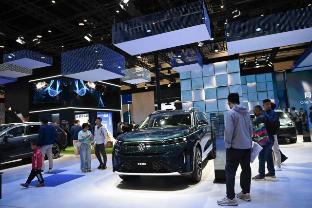 People visit the booth of the German automaker Volkswagen at the Beijing Auto Show in Beijing on April 26, 2026. (Photo by Pedro PARDO / AFP)