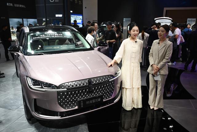 Two hosts introduce the Lincoln Corsair at the Beijing Auto Show in Beijing on April 26, 2026. (Photo by GREG BAKER / AFP)