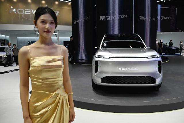 A model stands next to a Roewe 07 concept car at the Beijing Auto Show in Beijing on April 26, 2026. (Photo by GREG BAKER / AFP)