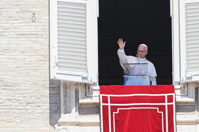 Pope Leo XIV waves from the window of the apostolic palace overlooking St. Peter's square during the Regina Coeli prayer in The Vatican on April 26, 2025. (Photo by Andreas SOLARO / AFP)