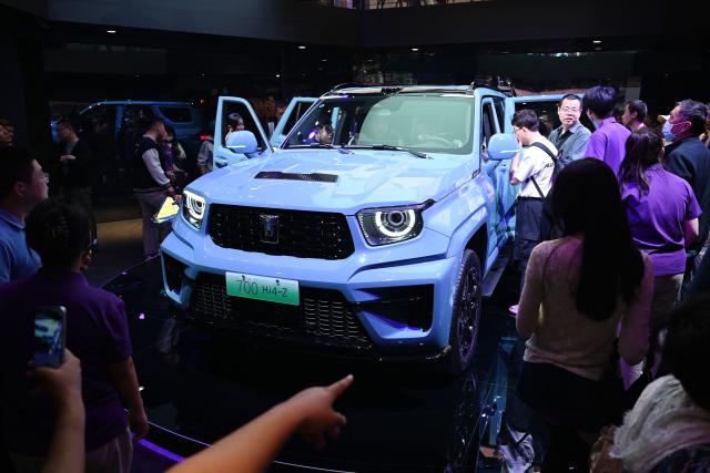 Visitors crowd around a Great Wall Motors sub-brand Tank 700 Hi4-Z at the Beijing Auto Show in Beijing on April 26, 2026. (Photo by GREG BAKER / AFP)