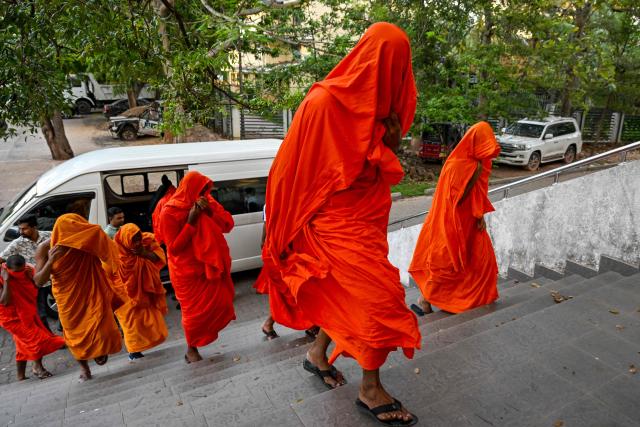 Sri Lankan monks arrive to appear before a court after their arrest in Negombo on April 26, 2026. Twenty-two Sri Lankan monks returning from Thailand were arrested on April 26 at the main international airport with 110 kilograms (242 pounds) of powerful cannabis, officials said. (Photo by Ishara S. KODIKARA / AFP)
