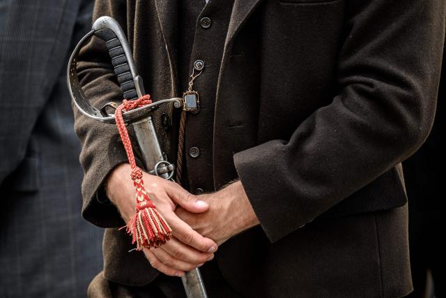 A citizen holds his sword as he walks to attend the Landsgemeinde, a traditional public, non-secret ballot conducted by majority rule, in Appenzell, eastern Switzerland, on April 26, 2026, where historically the only proof of citizenship required for men to enter the voting area was the display of a ceremonial sword or Swiss military sidearm. The open-air gathering, held annually, allows eligible citizens to decide cantonal laws and policies directly, preserving one of Switzerlands oldest forms of direct democracy. (Photo by Fabrice COFFRINI / AFP)