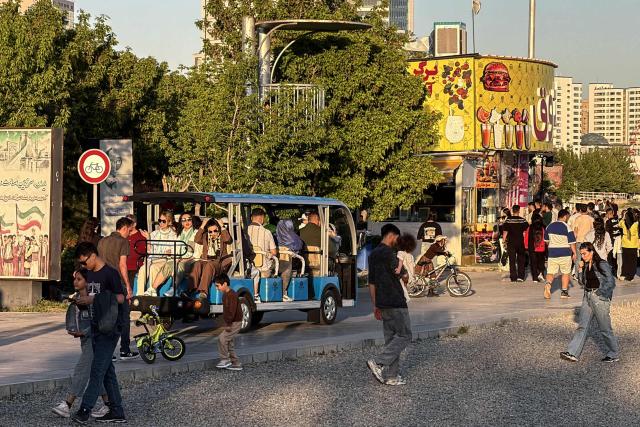 Iranians use provided carts for transportation at Game City at Chitgar Lake, an artificial recreational lake and park officially known as the Lake of the Martyrs of the Persian Gulf, in northwestern Tehran on April 26, 2026. Iran's foreign minister returned to Islamabad, Pakistan, for more consultations on April 26, as international mediators tried to keep peace talks on track despite the US President calling off his envoys' planned trip. (Photo by ATTA KENARE / AFP) / 