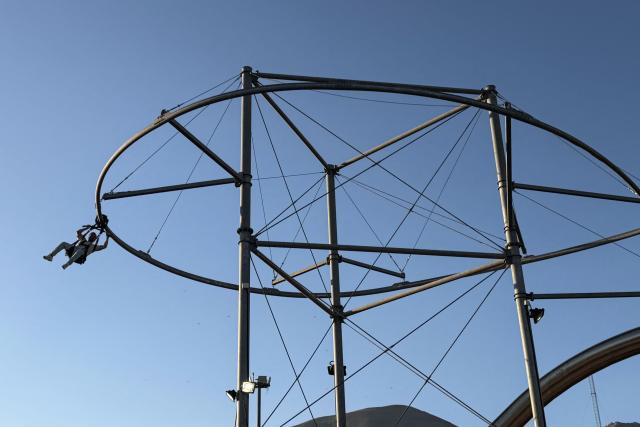 An Iranian enjoys an amusement ride at Game City at Chitgar Lake, an artificial recreational lake and park officially known as the Lake of the Martyrs of the Persian Gulf, in northwestern Tehran on April 26, 2026. Iran's foreign minister returned to Islamabad, Pakistan, for more consultations on April 26, as international mediators tried to keep peace talks on track despite the US President calling off his envoys' planned trip. (Photo by ATTA KENARE / AFP) / 