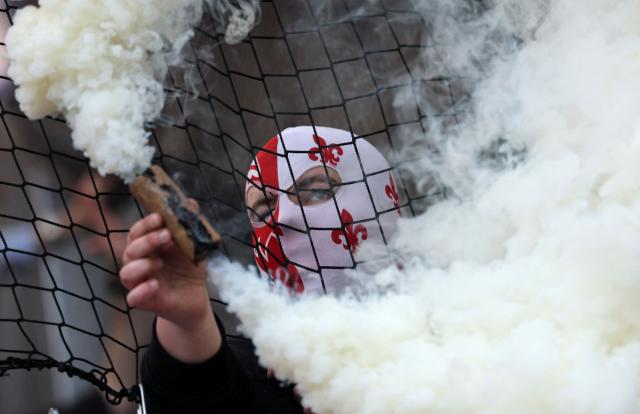 A Lille supporter holds a smoke flare in the stands during the French L1 football match between Paris FC and LOSC Lille at the Stade Jean-Bouin in Paris, on April 26, 2026. (Photo by FRANCK FIFE / AFP)