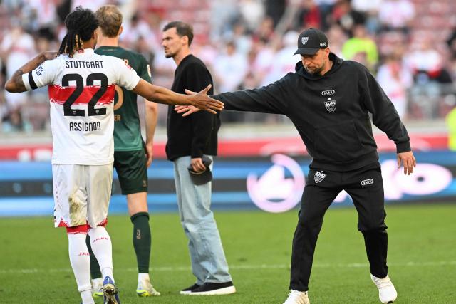 Stuttgart's German head coach Sebastian Hoeness (R) shakes hands with Stuttgart's French defender #22 Lorenz Assignon after the German first division Bundesliga football match between VfB Stuttgart and SV Werder Bremen in Stuttgart, southwestern Germany on April 26, 2026. (Photo by THOMAS KIENZLE / AFP) / DFL REGULATIONS PROHIBIT ANY USE OF PHOTOGRAPHS AS IMAGE SEQUENCES AND/OR QUASI-VIDEO