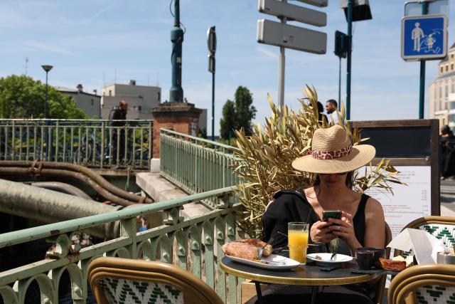 A woman sits at the terrasse of a cafe at the Canal de l'Ourcq in Pantin, suburb of Paris on April 26, 2026. (Photo by Charlotte SIEMON / AFP)