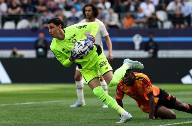 Lille's Turkish goalkeeper #01 Berke Ozer (L) gathers the ball during the French L1 football match between Paris FC and LOSC Lille at the Stade Jean-Bouin in Paris, on April 26, 2026. (Photo by FRANCK FIFE / AFP)