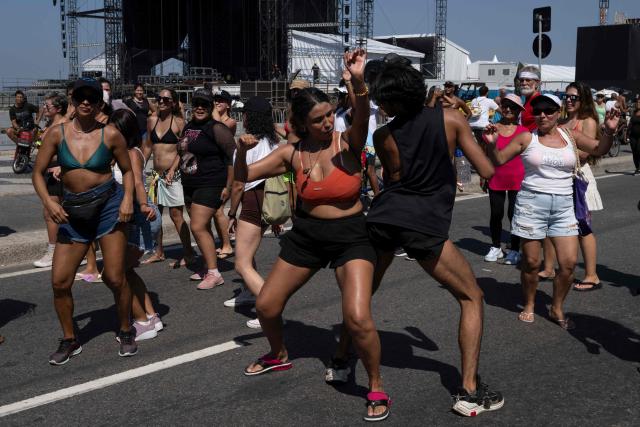 Fans of Colombian singer Shakira learn to dance the choreography of her song "Waka Waka (This Time for Africa)" at the Copacabana promenade, in front of the stage where she will perform in one week, in Rio de Janeiro, Brazil, on April 26, 2026. (Photo by Pablo PORCIUNCULA / AFP)