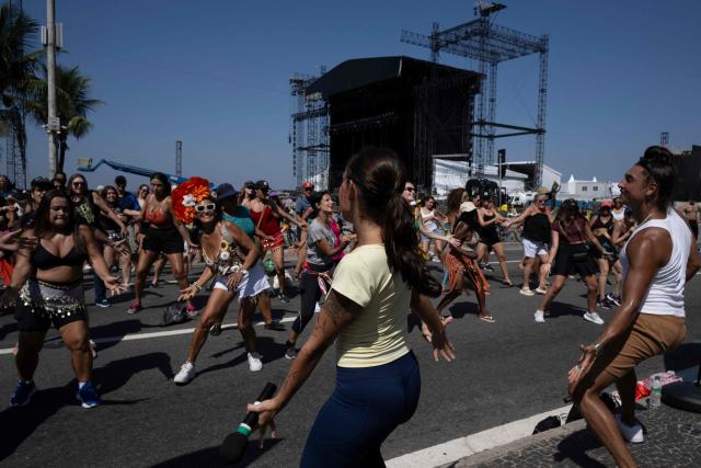 Fans of Colombian singer Shakira learn to dance the choreography of her song "Waka Waka (This Time for Africa)" at the Copacabana promenade, in front of the stage where she will perform in one week, in Rio de Janeiro, Brazil, on April 26, 2026. (Photo by Pablo PORCIUNCULA / AFP)