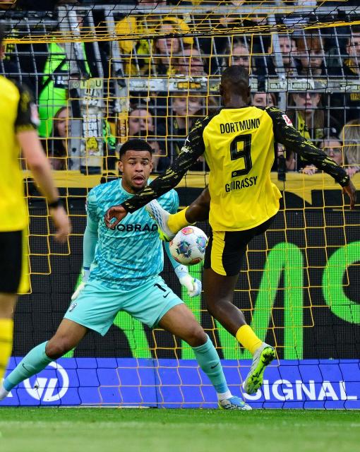 Dortmund's Guinean forward #09 Serhou Guirassy (R) scores the 2-0 goal past Freiburg's German goalkeeper #01 Noah Atubolu during the German first division Bundesliga football match between BVB Borussia Dortmund and SC Freiburg in Dortmund, western Germany on April 26, 2026. (Photo by INA FASSBENDER / AFP) / DFL REGULATIONS PROHIBIT ANY USE OF PHOTOGRAPHS AS IMAGE SEQUENCES AND/OR QUASI-VIDEO  ALTERNATIVE CROP