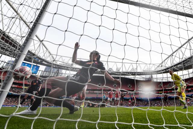 Lyon's Norwegian midfielder #15 Ingrid Syrstad Engen (L) tries to stop an own goal for Arsenal's first goal during the women's UEFA Champions League first-leg semi-final football match between Arsenal and OL Lyonnes at the Emirates Stadium, north London, on April 26, 2026. (Photo by Glyn KIRK / AFP)
