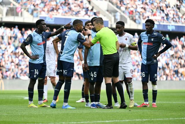 French referee Franзois Letexier (C) speaks with Le Havre’s players during the French L1 football match between Le Havre AC and FC Metz at the Oceane Stadium in Le Havre on April 26, 2026. (Photo by Lou BENOIST / AFP)