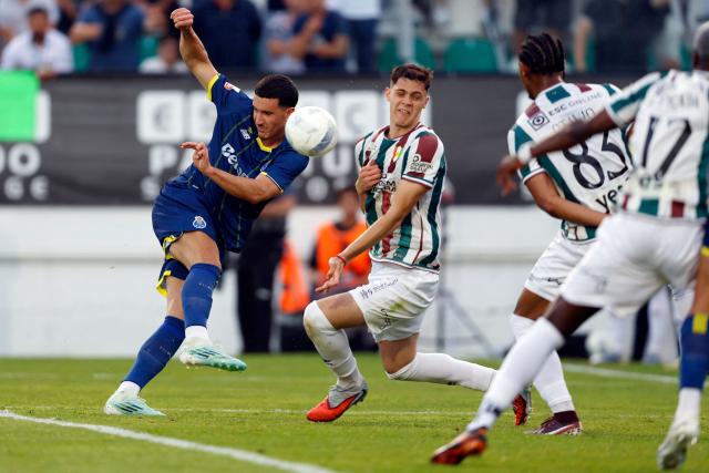 FC Porto's Turkish forward #27 Deniz Gul (L) and Estrela da Amadora's Serbian defender #04 Stefan Lekovic fight for the ball during the Portuguese League football match between CF Estrela da Amadora and FC Porto at Jose Gomes stadium in Amadora, on April 26, 2026. (Photo by FILIPE AMORIM / AFP)