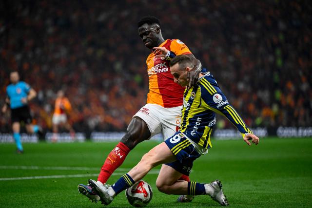 Galatasaray's Colombian defender Davinson Sanchez (L) fights for the ball with Fenerbahce's Turkish forward #09 Kerem Akturkoglu during the Turkish Super lig football match between Fenerbahce and Galatasaray at the Rams Park stadium in Istanbul, on April 26, 2026. (Photo by Yasin AKGUL / AFP)