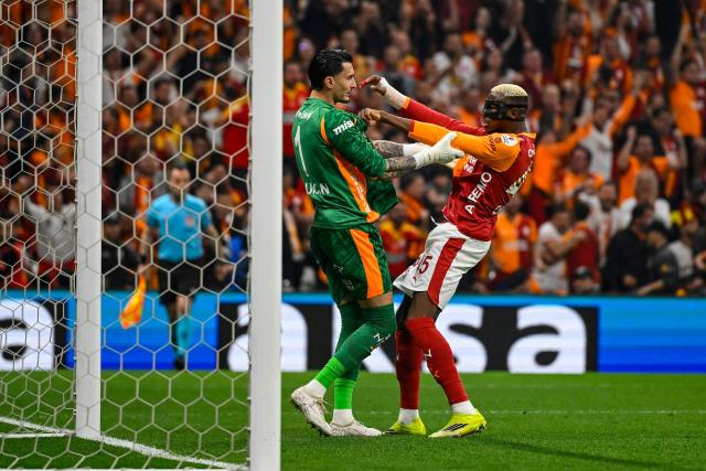 Galatasaray's Nigerian forward Victor Osimhen congratulates Galatasaray's Turkish goalkeeper #01 Ugurcan Cakir after he saved a penalty during the Turkish Super lig football match between Fenerbahce and Galatasaray at the Rams Park stadium in Istanbul, on April 26, 2026. (Photo by Yasin AKGUL / AFP)
