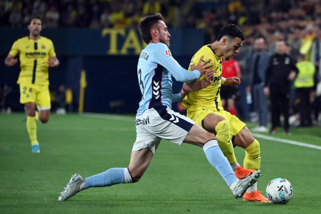 Celta Vigo's Spanish defender #03 Oscar Mingueza Garcia (L) and Villarreal's French forward #09 Georges Mikautadze fight for the ball during the Spanish league football match between Villarreal CF and RC Celta de Vigo at La Ceramica Stadium in Vila-real on April 26, 2026. (Photo by JOSE JORDAN / AFP)