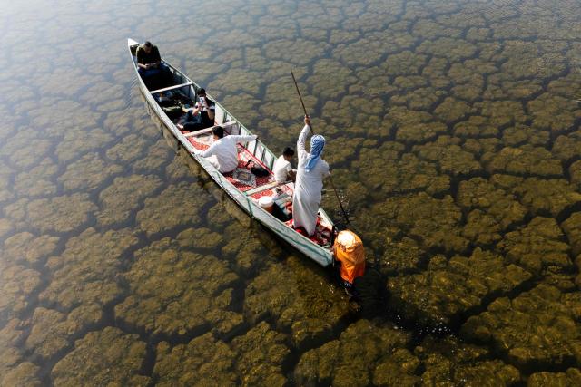 An aerial photograph of a local fishing boat in the Iraqi Hawizeh Marsh in Maysan province, southern Iraq, after water returned due to rainfall following a long period of drought on April 26, 2026. Hawizeh is a transboundary marsh shared by Iraq and Iran. (Photo by Hussein FALEH / AFP)