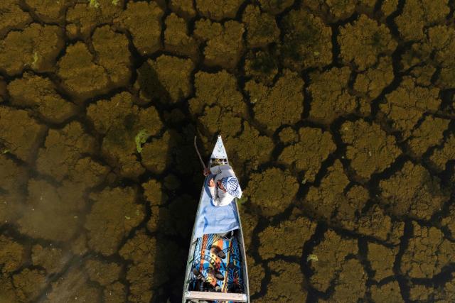 An aerial photograph of a local fishing boat in the Iraqi Hawizeh Marsh in Maysan province, southern Iraq, after water returned due to rainfall following a long period of drought on April 26, 2026. Hawizeh is a transboundary marsh shared by Iraq and Iran. (Photo by Hussein FALEH / AFP)
