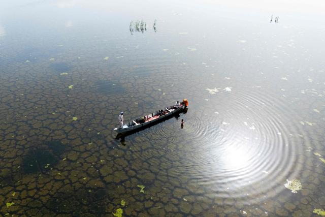 An aerial photograph of a local fishing boat in the Iraqi Hawizeh Marsh in Maysan province, southern Iraq, after water returned due to rainfall following a long period of drought on April 26, 2026. Hawizeh is a transboundary marsh shared by Iraq and Iran. (Photo by Hussein FALEH / AFP)