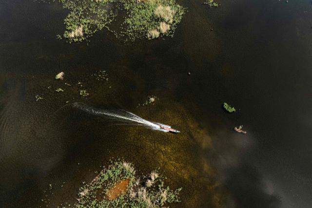 An aerial photograph of a local fishing boat in the Iraqi Hawizeh Marsh in Maysan province, southern Iraq, after water returned due to rainfall following a long period of drought on April 26, 2026. Hawizeh is a transboundary marsh shared by Iraq and Iran. (Photo by Hussein FALEH / AFP)