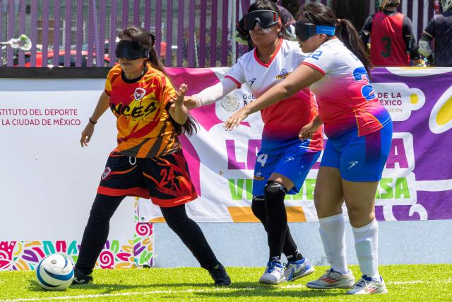 Players of Puebla's Topas and Mexicali's Linces fight for the ball during the women’s final of the football tournament of the sight-impaired people at the Utopia Mixihuca sport complex in Mexico City on April 26, 2026. (Photo by Gerardo MAGALLON / AFP)
