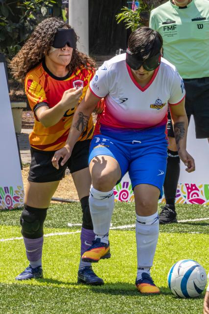 Players of Puebla's Topas and Mexicali's Linces fight for the ball during the women’s final of the football tournament of the sight-impaired people at the Utopia Mixihuca sport complex in Mexico City on April 26, 2026. (Photo by Gerardo MAGALLON / AFP)