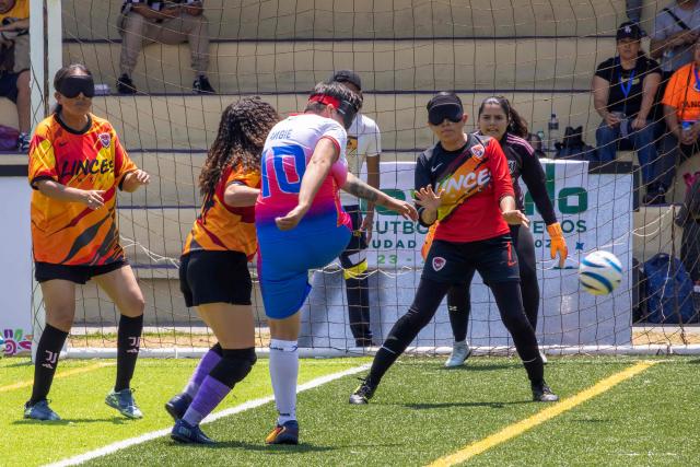 Players of Puebla's Topas and Mexicali's Linces fight for the ball during the women’s final of the football tournament of the sight-impaired people at the Utopia Mixihuca sport complex in Mexico City on April 26, 2026. (Photo by Gerardo MAGALLON / AFP)