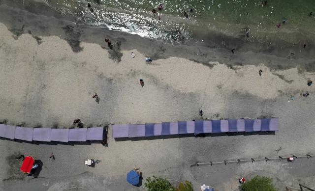 An aerial view shows beachgoers at Playa Gaira in Santa Marta, Colombia, on April 26, 2026, during the International Conference on the Just Transition Away from Fossil Fuels. (Photo by Raul ARBOLEDA / AFP)