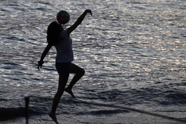 A young girl plays with a ball at Pozos Colorados Beach in Santa Marta, Colombia, on April 26, 2026, during the International Conference on the Just Transition Away from Fossil Fuels. (Photo by Raul ARBOLEDA / AFP)