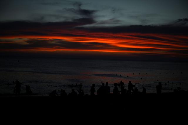 Beachgoers are seen at sunset at Pozos Colorados Beach in Santa Marta, Colombia, on April 26, 2026, during the International Conference on the Just Transition Away from Fossil Fuels. (Photo by Raul ARBOLEDA / AFP)