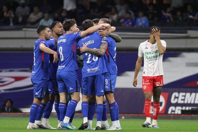 Cruz Azul's Argentine forward #20 Jose Paradela (C) celebrates with teammates after scoring the opening goal during the Liga MX Clausura football match between Cruz Azul and Necaxa at Banorte Stadium in Mexico City on April 26, 2026. (Photo by Victor Cruz / AFP)