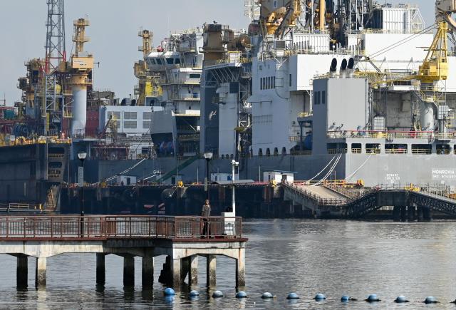 A man looks on from a jetty next to vessels under maintenance at the Sembawang shipyard in Singapore on April 27, 2026. (Photo by Roslan RAHMAN / AFP)