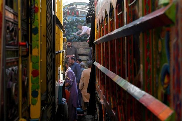 A trader (C) arranges watermelons for sale on his truck at a wholesale market in Lahore on April 27, 2026. (Photo by Arif ALI / AFP)