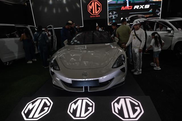 Visitors look at new cars priced in U.S. dollars during the 14th edition of Venezuela’s largest automotive exhibition, "AutoFest 2026," at the Centro Comercial Ciudad Tamanaco (CCCT) in Caracas on April 26, 2026. (Photo by Juan BARRETO / AFP)