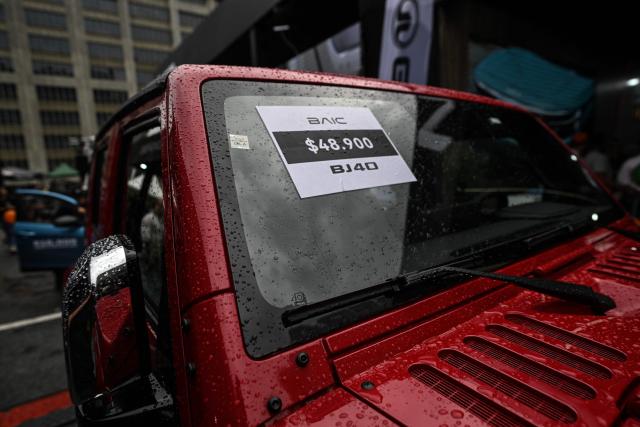 A sign with a price in U.S. dollars on a BAIC jeep is pictured during the 14th edition of Venezuela’s largest automotive exhibition, "AutoFest 2026," at the Centro Comercial Ciudad Tamanaco (CCCT) in Caracas on April 26, 2026. (Photo by Juan BARRETO / AFP)