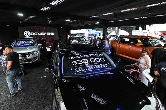 Visitors look at new cars priced in U.S. dollars during the 14th edition of Venezuela’s largest automotive exhibition, "AutoFest 2026," at the Centro Comercial Ciudad Tamanaco (CCCT) in Caracas on April 26, 2026. (Photo by Juan BARRETO / AFP)
