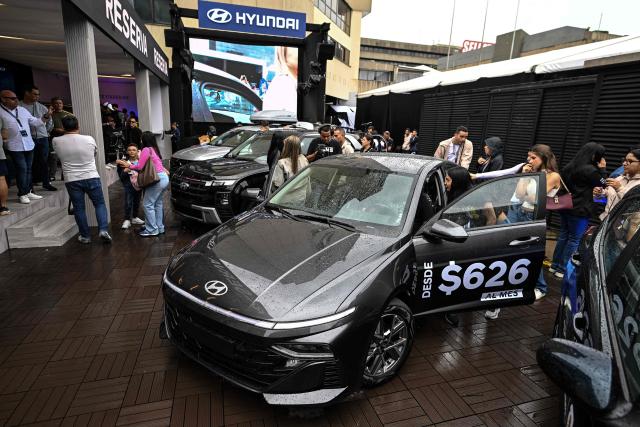 Visitors look at new cars priced in U.S. dollars during the 14th edition of Venezuela’s largest automotive exhibition, "AutoFest 2026," at the Centro Comercial Ciudad Tamanaco (CCCT) in Caracas on April 26, 2026. (Photo by Juan BARRETO / AFP)