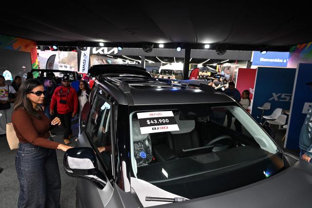 Visitors look at new cars priced in U.S. dollars during the 14th edition of Venezuela’s largest automotive exhibition, "AutoFest 2026," at the Centro Comercial Ciudad Tamanaco (CCCT) in Caracas on April 26, 2026. (Photo by Juan BARRETO / AFP)