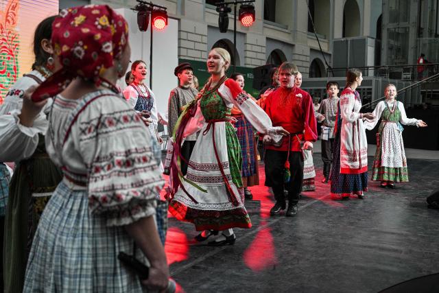 Children from a folk group wearing traditional costumes perform at the fair of folk and arts craft of Russia, in central Moscow on March 4, 2026. (Photo by Hector RETAMAL / AFP)
