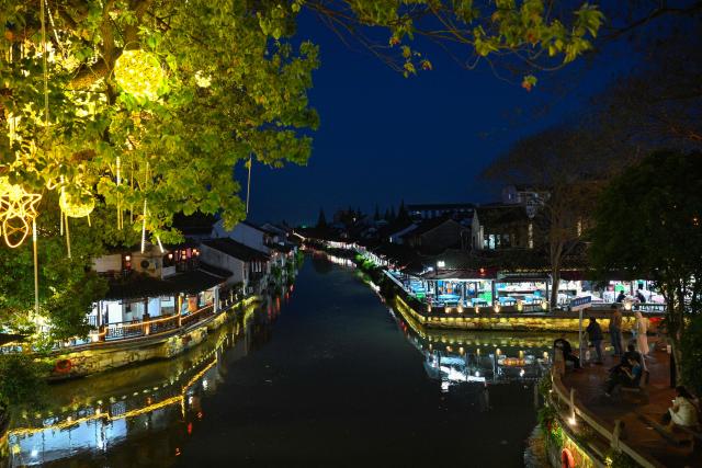 People visit the Fengjing Ancient Town on the outskirts of Shanghai on April 26, 2026. (Photo by ADEK BERRY / AFP)