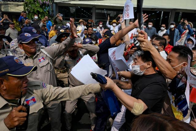 Chinese and Cambodian nationals believed to be Huione Pay creditors clash with police and security personnel during a protest near the National Bank of Cambodia (NBC) headquarters in Phnom Penh on April 27, 2026. Dozens of Chinese nationals protested outside Cambodia's central bank on April 27, calling for their accounts with a financial services firm accused of laundering illicit funds for cybercriminals to be unfrozen. (Photo by TANG CHHIN Sothy / AFP)