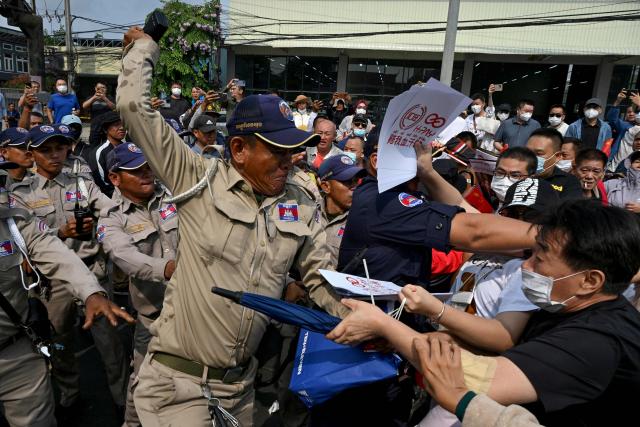 Chinese and Cambodian nationals believed to be Huione Pay creditors clash with police and security personnel during a protest near the National Bank of Cambodia (NBC) headquarters in Phnom Penh on April 27, 2026. Dozens of Chinese nationals protested outside Cambodia's central bank on April 27, calling for their accounts with a financial services firm accused of laundering illicit funds for cybercriminals to be unfrozen. (Photo by TANG CHHIN Sothy / AFP)