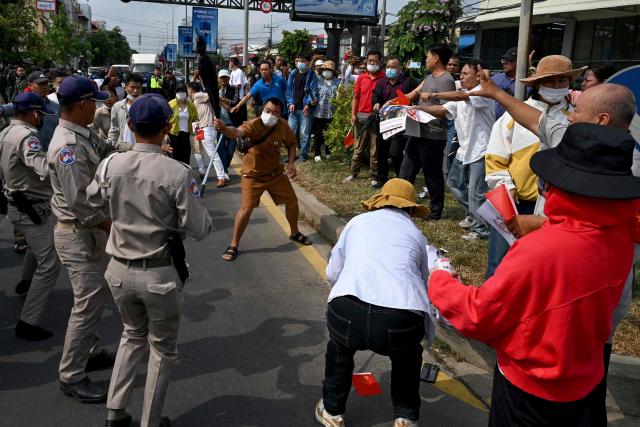 Chinese and Cambodian nationals believed to be Huione Pay creditors clash with police and security personnel during a protest near the National Bank of Cambodia (NBC) headquarters in Phnom Penh on April 27, 2026. Dozens of Chinese nationals protested outside Cambodia's central bank on April 27, calling for their accounts with a financial services firm accused of laundering illicit funds for cybercriminals to be unfrozen. (Photo by TANG CHHIN Sothy / AFP)