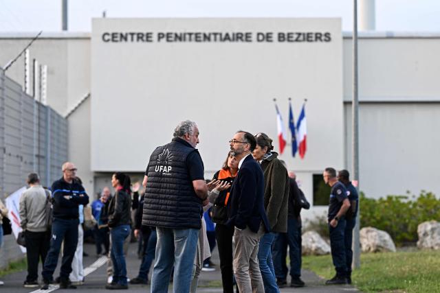 Robert Menard (R), Mayor of Beziers, speaks with Ufap union's secretary David Parmentier as striking penitentiary staff block access to the entrance of the prison in Beziers, southern France, on April 27, 2026, after the CGT and Ufap-Unsa unions called for a blockade of prisons to draw attention to prison overcrowding and “fill the 5,000 vacant positions.” (Photo by Gabriel BOUYS / AFP)