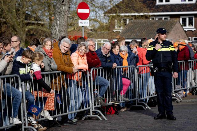 A Dutch police officer stands as fans gather along the route the Dutch royal family is set to take as part of the King's Day celebrations through the Frisian town of Dokkum, on April 27, 2026. The Dutch King is celebrating his 59th birthday with his family in Dokkum. (Photo by Ramon van Flymen / ANP / AFP) / Netherlands OUT