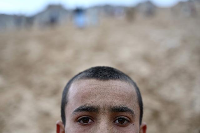 An Afghan visitor poses as he rests after backflipping down a steep and sandy mountainside on a weekend at the Sayad area of Reg-e-Rawan in Kapisa province on April 24, 2026. Hundreds of visitors travel each weekend to Reg-e-Rawan -- "the moving sands" in Dari -- to practice parkour or roll down the honey-coloured sand in Kapisa province and to unwind beside breathtaking views. (Photo by Wakil KOHSAR / AFP)