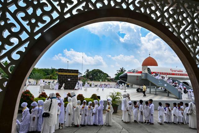 Kindergarten students and teachers practice the ritual of circumambulation around a replica of the Kaaba at a Hajj pilgrimage centre in Banda Aceh on April 27, 2026. (Photo by CHAIDEER MAHYUDDIN / AFP)