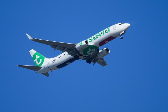 (FILES) A low-cost Air France subsidiary Transavia plane flies over Nantes, western France, on April 13, 2026. Transavia, the low-cost carrier of the Air France-KLM group, will adjust its scheduled flight program for May and June 2026 to optimize its costs in response to the surge in kerosene prices linked to the war in the Middle East, a spokesperson told AFP on April 26, 2026, confirming a report by RMC. (Photo by Loic VENANCE / AFP)